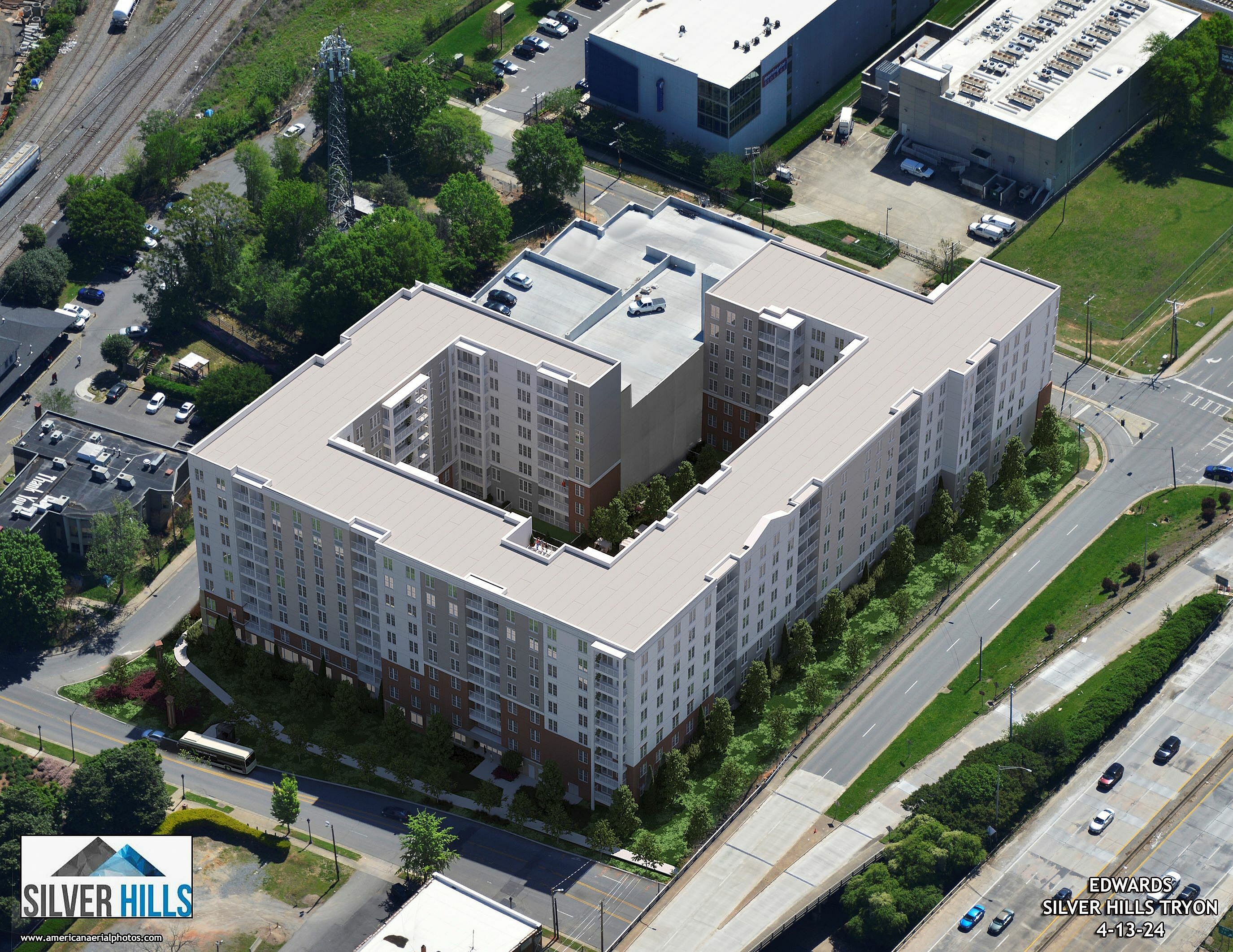 Aerial view of the modern Silver Hills Tryon apartment complex featuring expansive green surroundings and strategically placed near urban amenities.
