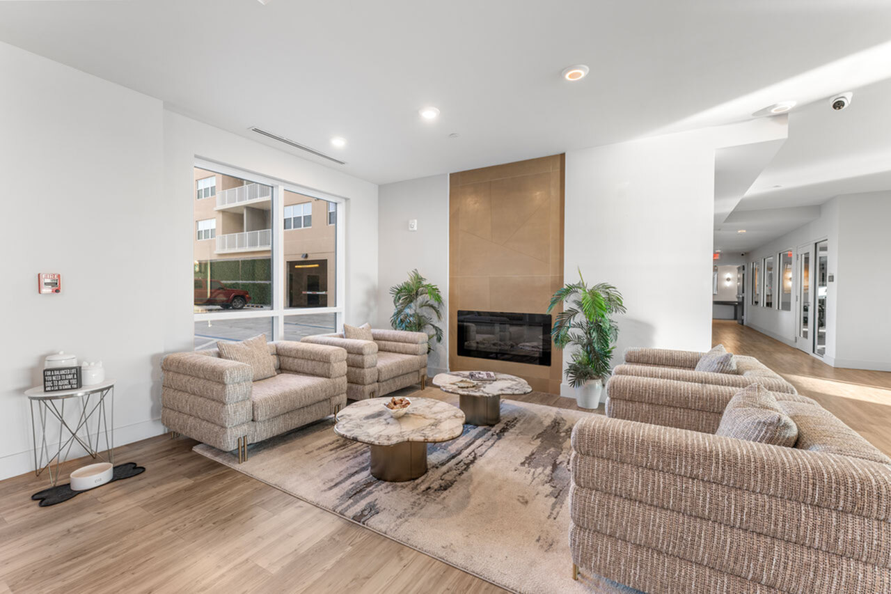 Inviting lounge area with cozy seating, stylish marble tables, and a modern fireplace, perfect for relaxation and entertaining.