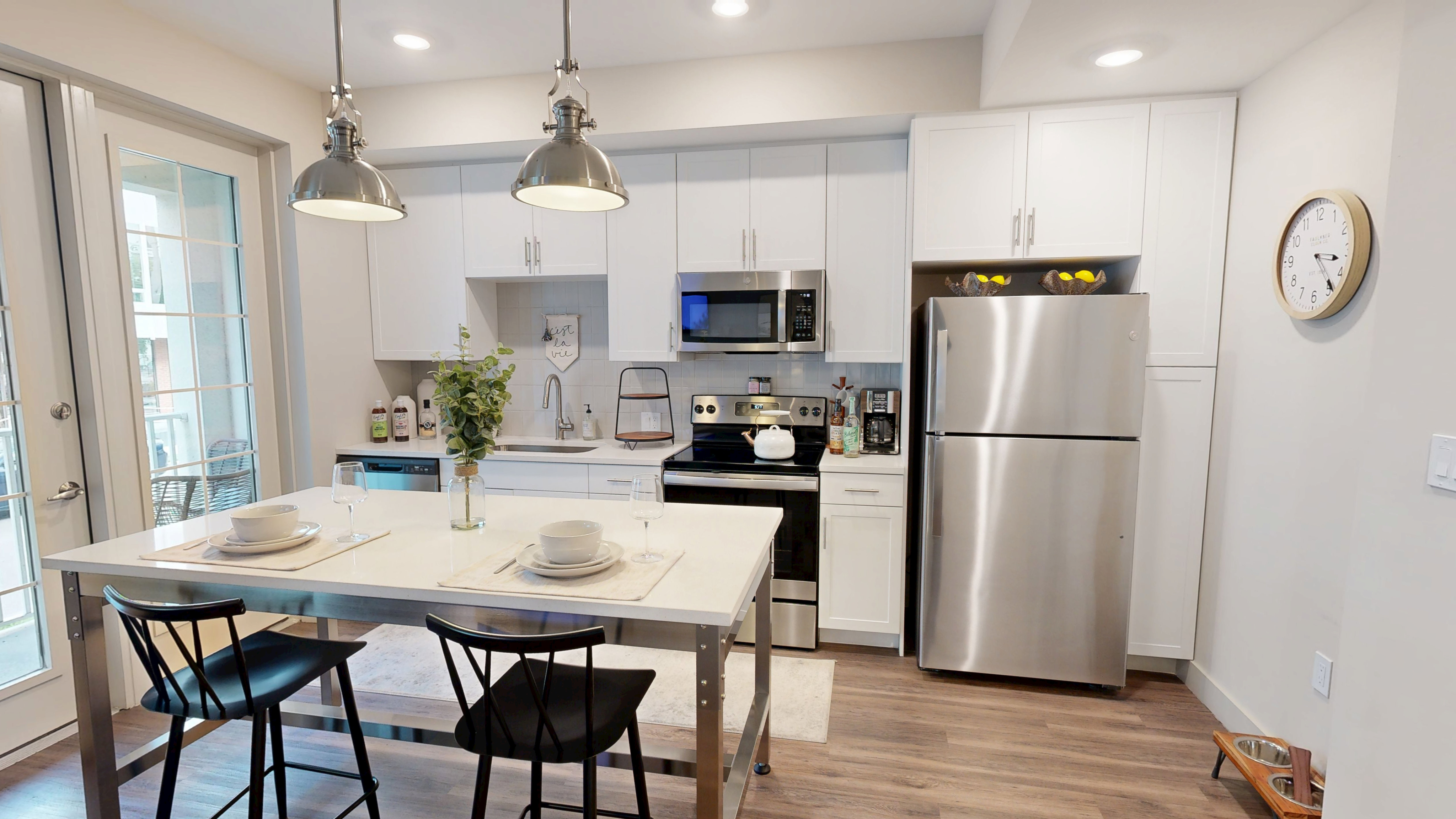 Modern kitchen with sleek stainless steel appliances, a stylish breakfast bar, and elegant pendant lighting.
