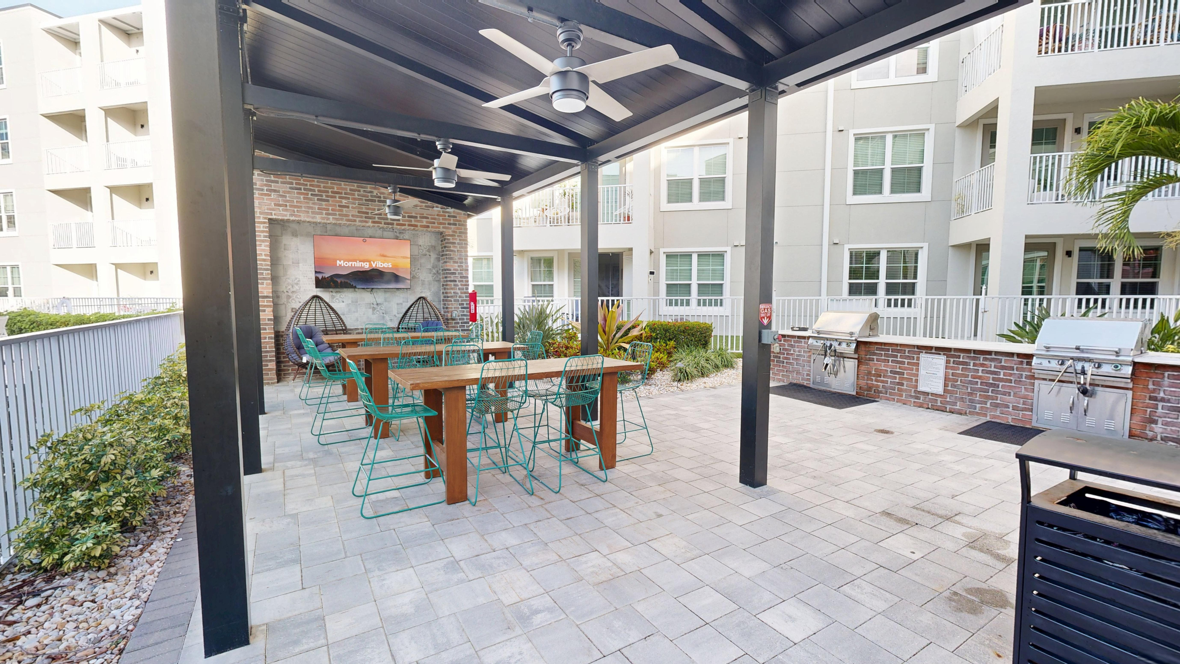 Elegant outdoor space featuring modern seating, stylish decor, and built-in grills for a perfect community gathering.