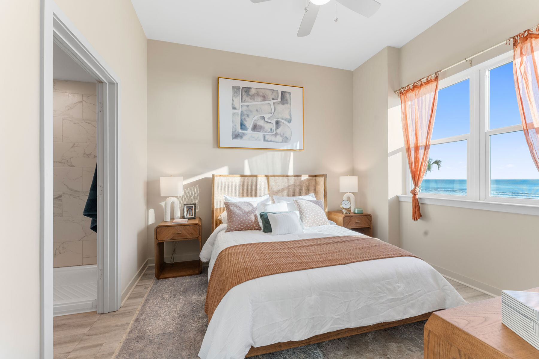 Bright, inviting bedroom with ocean view, featuring cozy bed, elegant decor, and soft natural lighting.