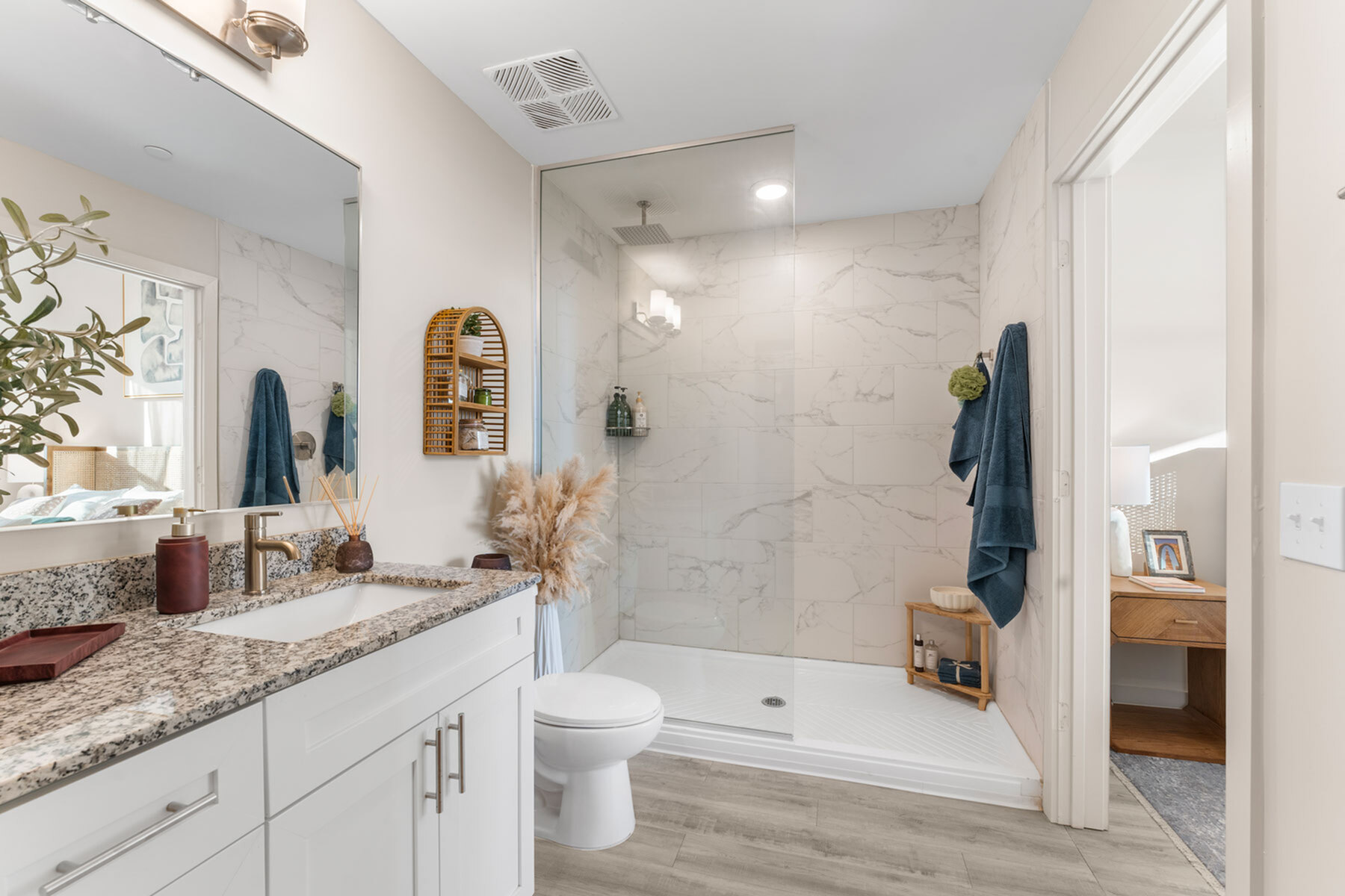 Elegant modern bathroom with marble tile shower, granite countertop, and chic decor accents.
