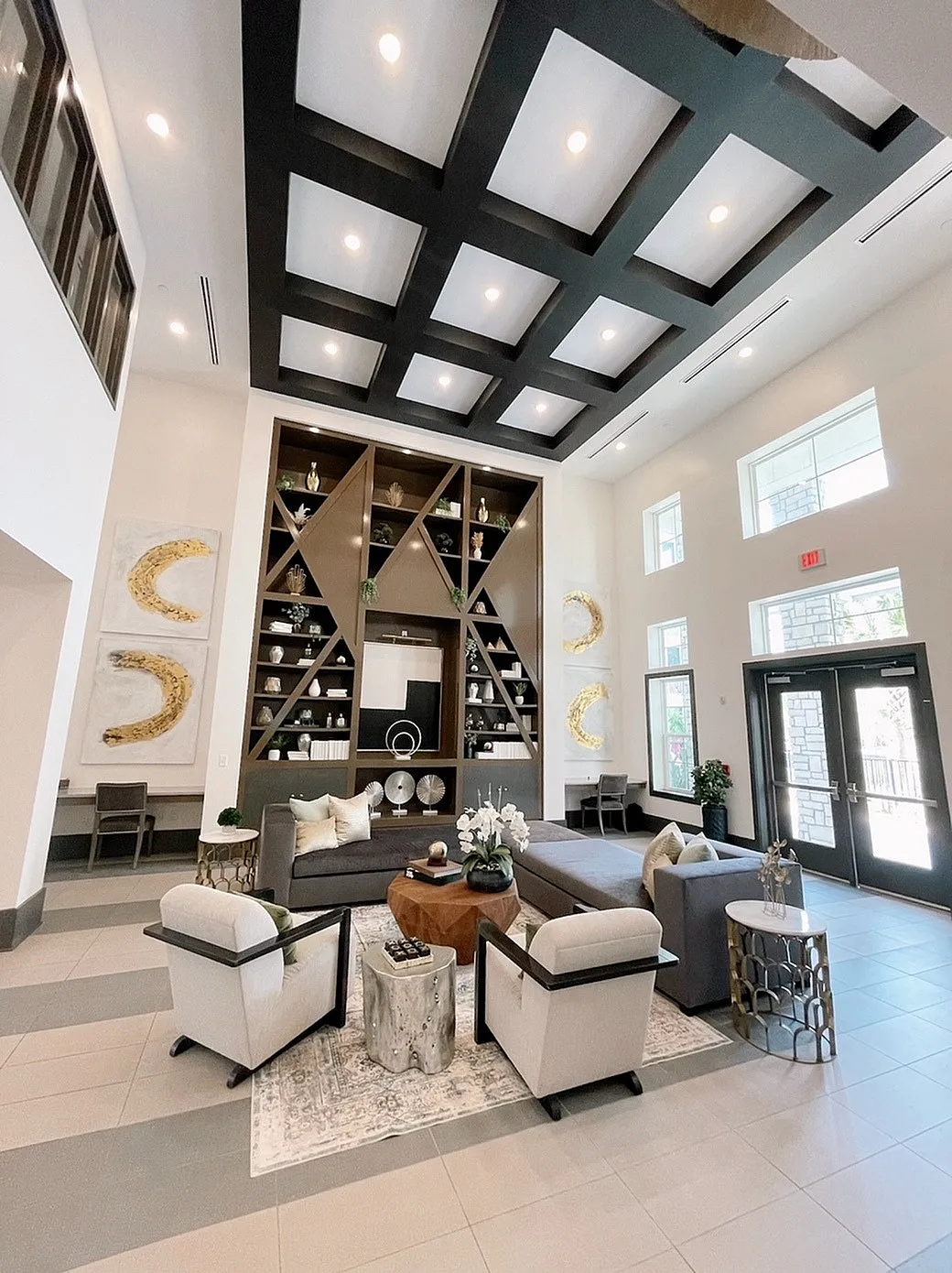 Luxurious lobby with high ceilings, modern geometric shelving, and elegant seating area.