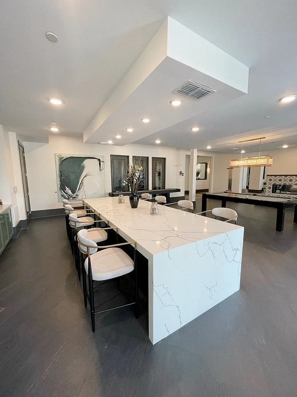Elegant communal space with a stunning marble island, chic bar stools, and modern lighting, perfect for entertaining.