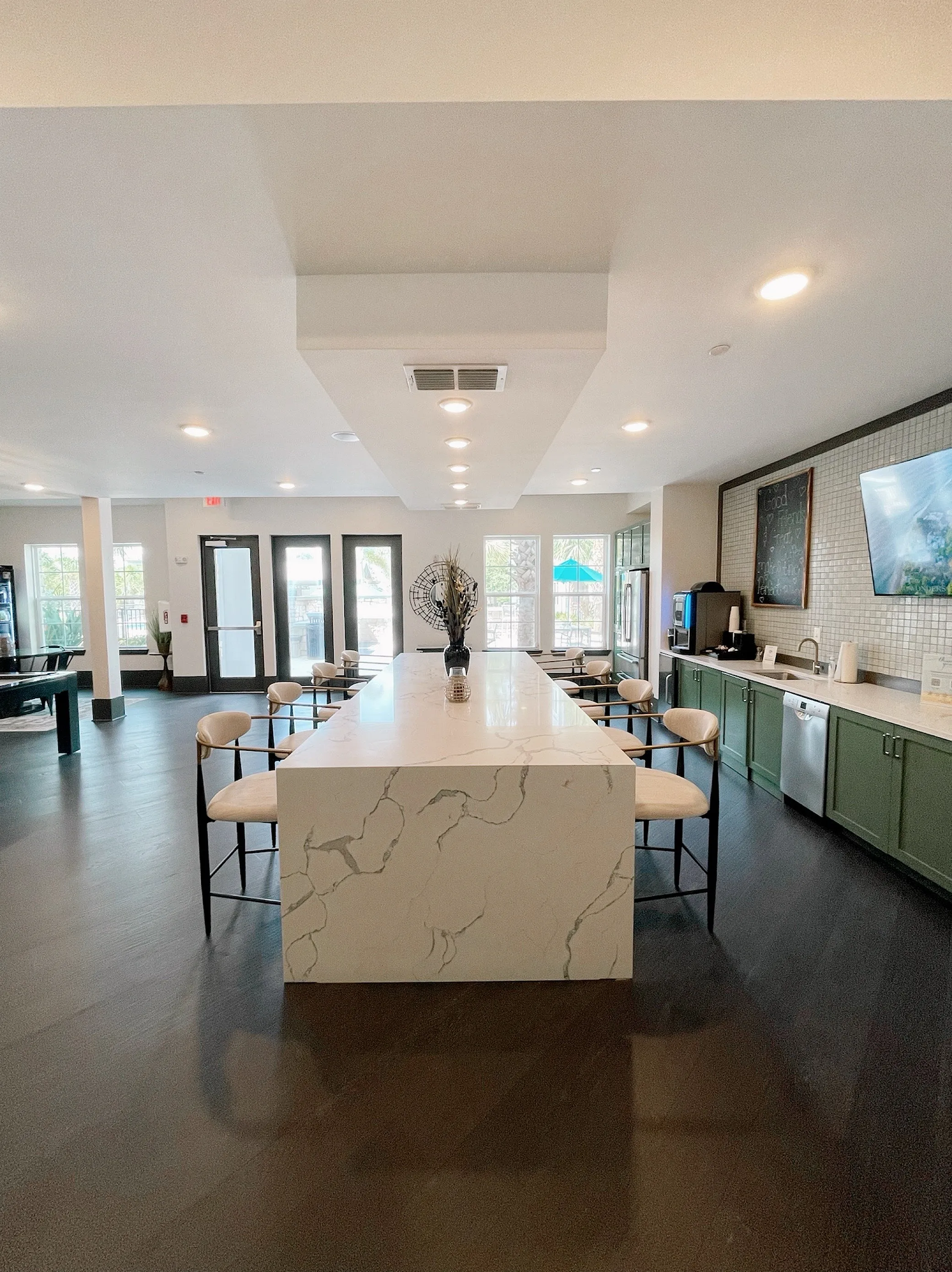 Contemporary communal kitchen with elegant marble island, sleek barstools, and modern cabinetry, perfect for social gatherings.