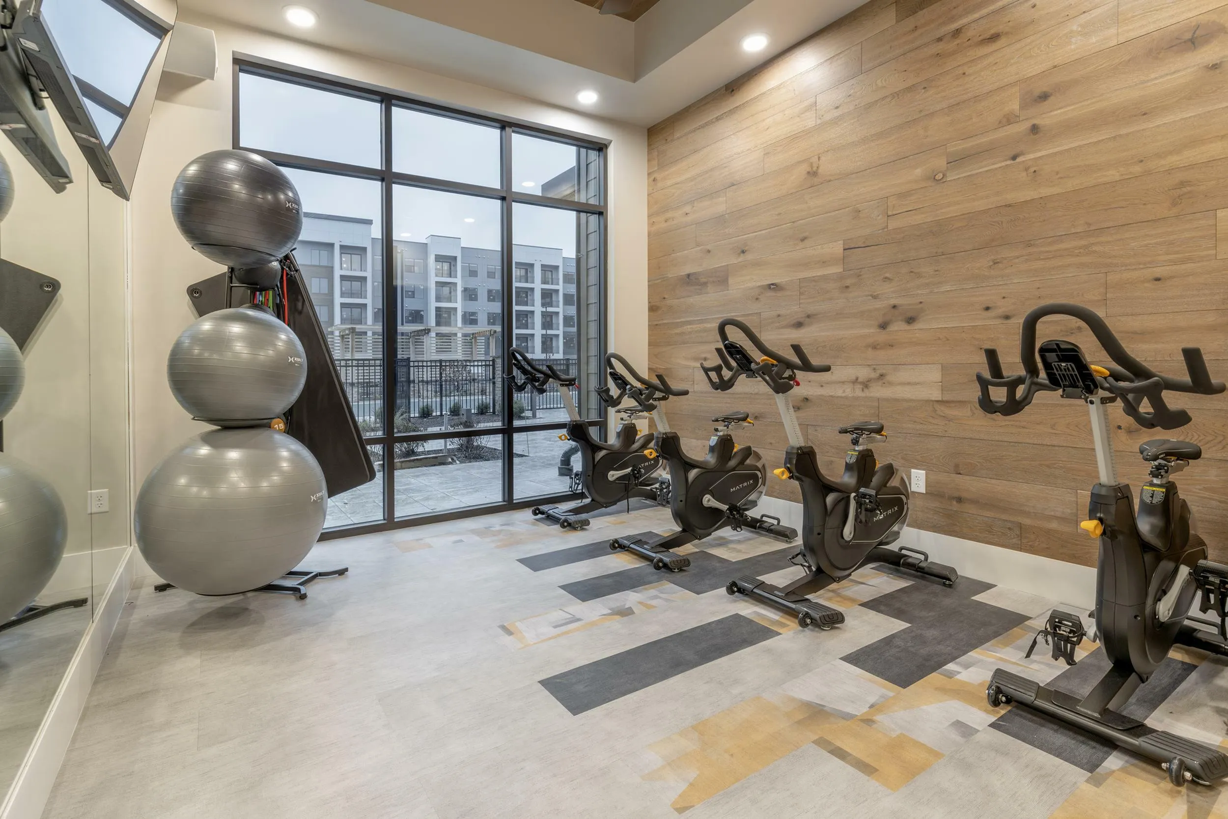 Modern fitness studio featuring exercise bikes and large windows with natural light.