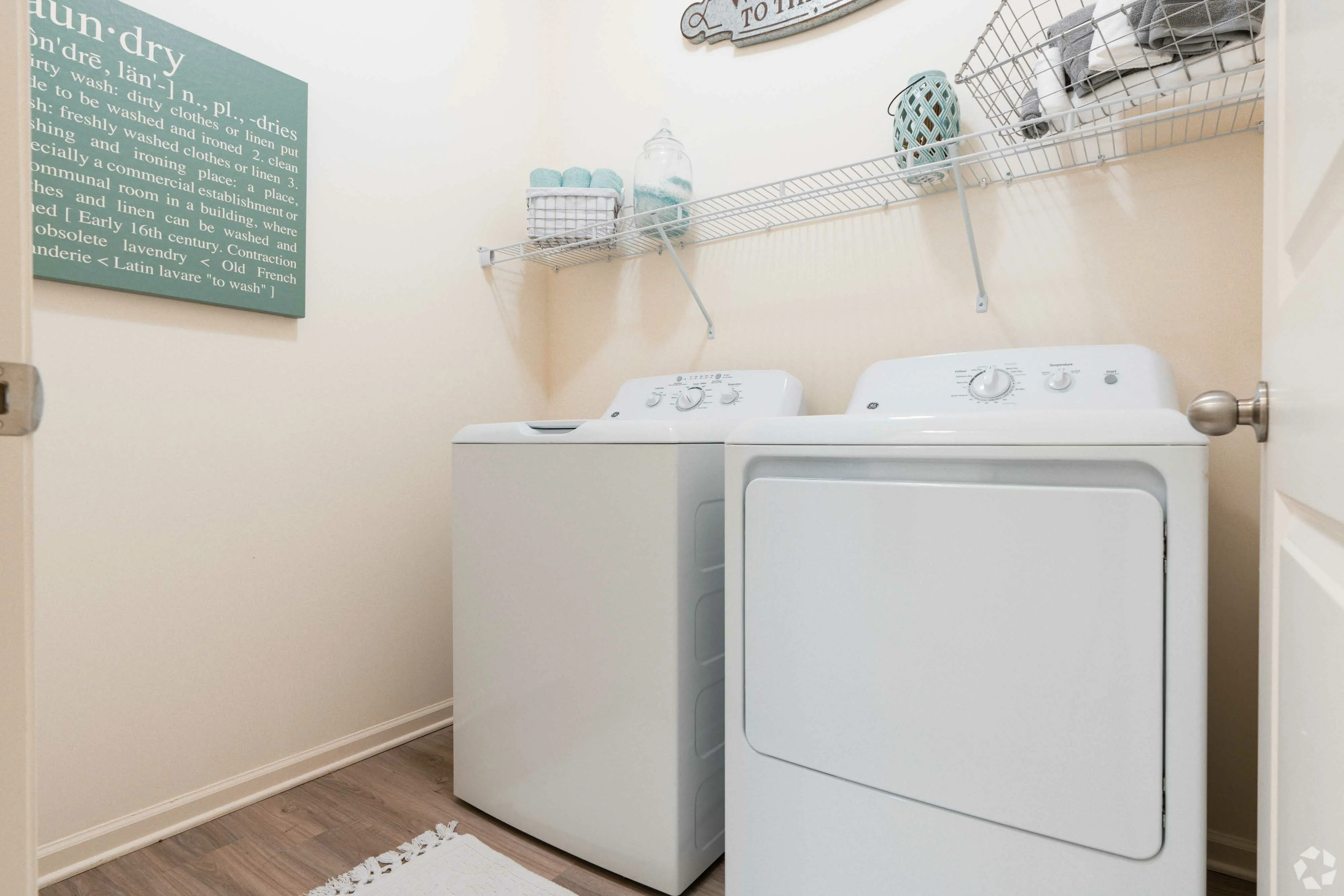 Bright laundry room with sleek washer and dryer, equipped with stylish shelving.