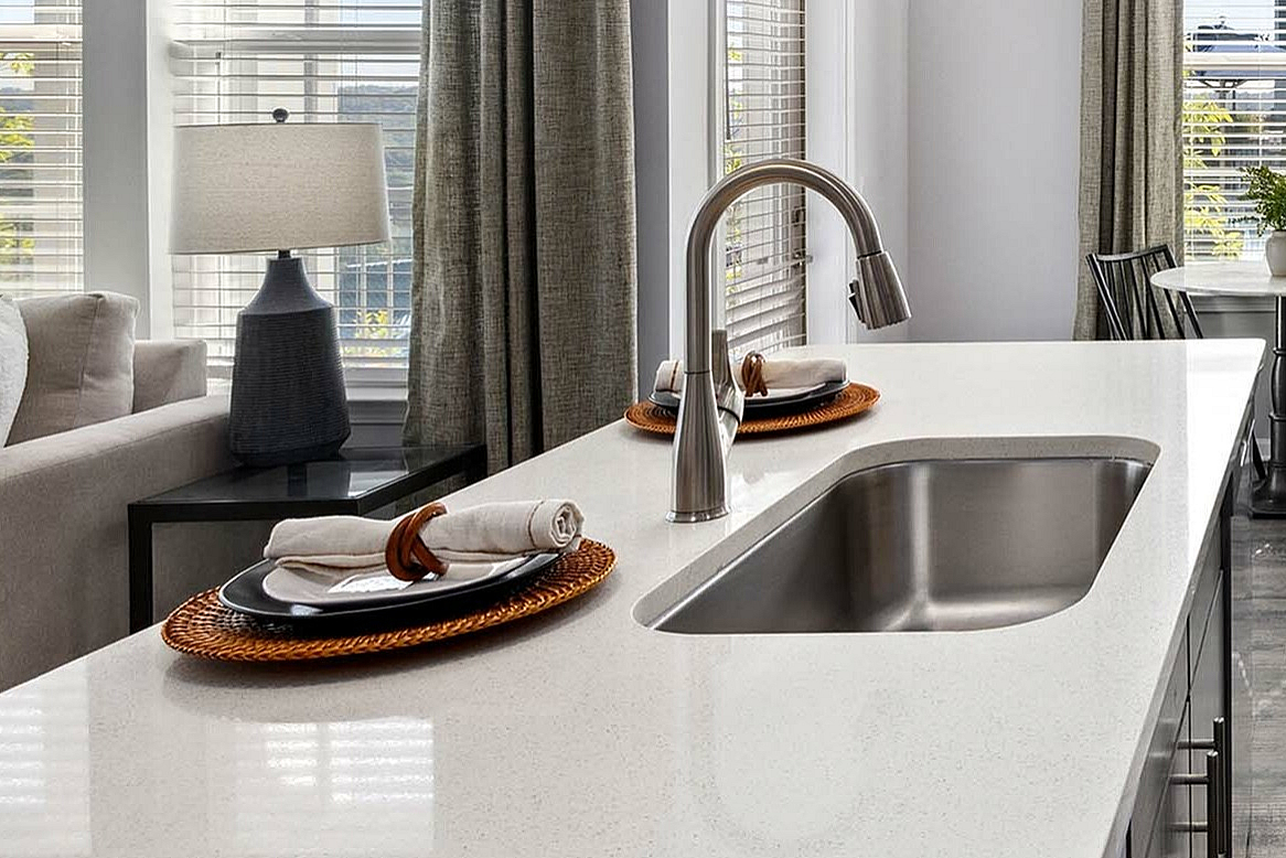 Bright, modern kitchen with sleek appliances, elegant pendant lighting, and a cozy dining nook by a sunlit window.