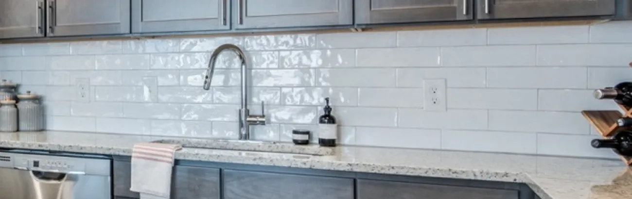 Modern kitchen with sleek granite countertops, stylish subway tile backsplash, and contemporary cabinetry, perfect for culinary enthusiasts.