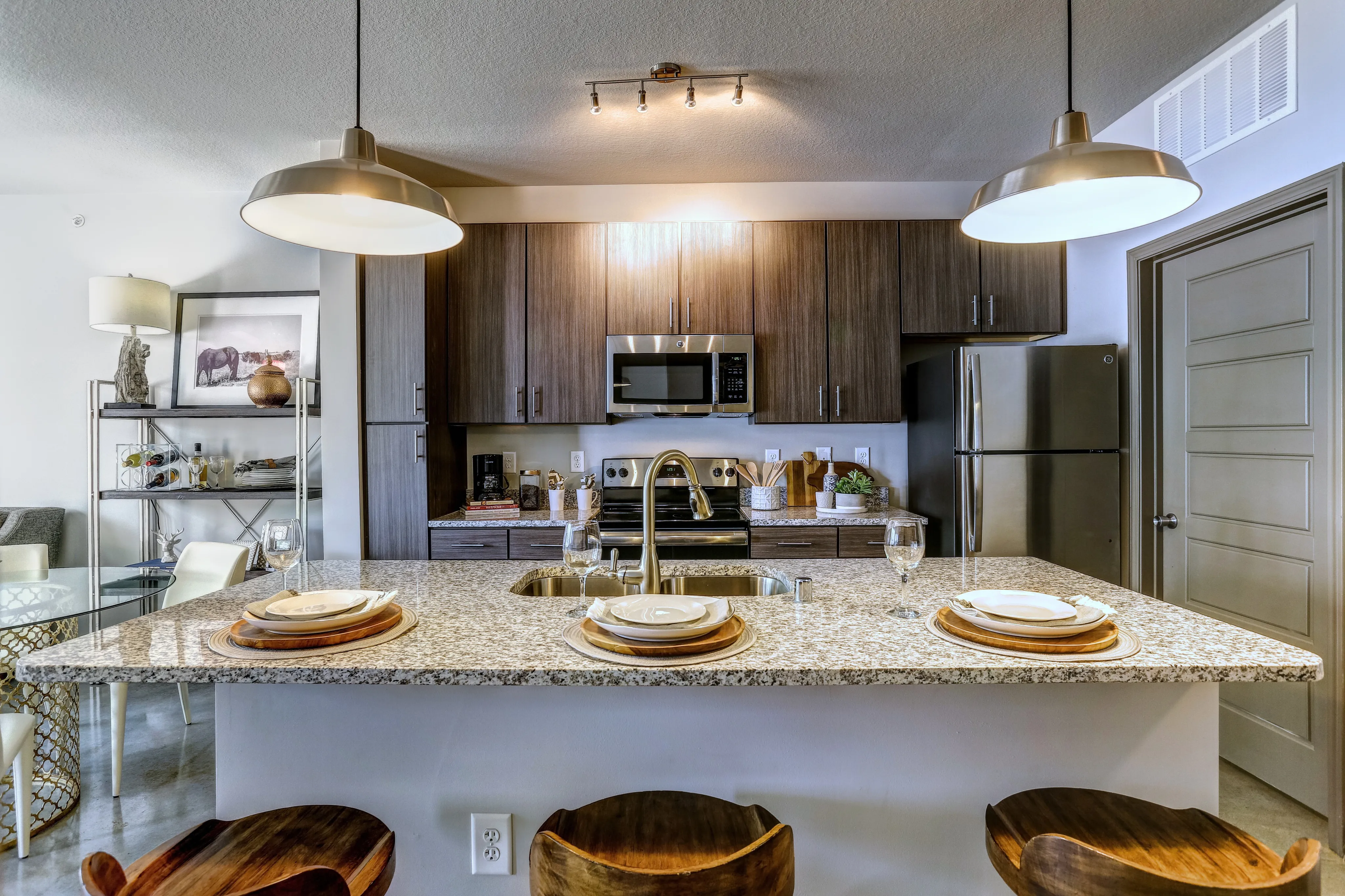 Contemporary kitchen with sleek granite countertops, stylish wooden cabinets, and modern stainless steel appliances, perfect for culinary creativity.