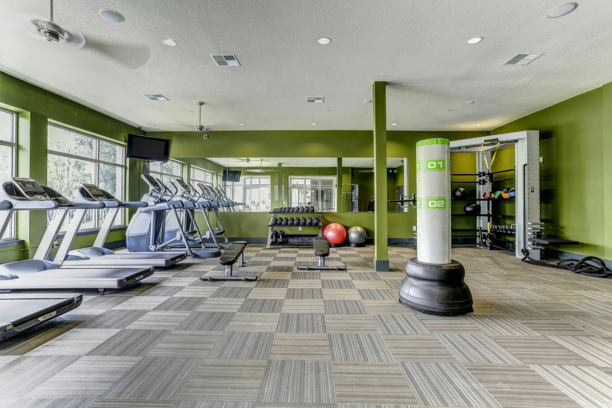Contemporary fitness center with state-of-the-art treadmills, free weights, and a sleek boxing area, designed for optimal workouts.