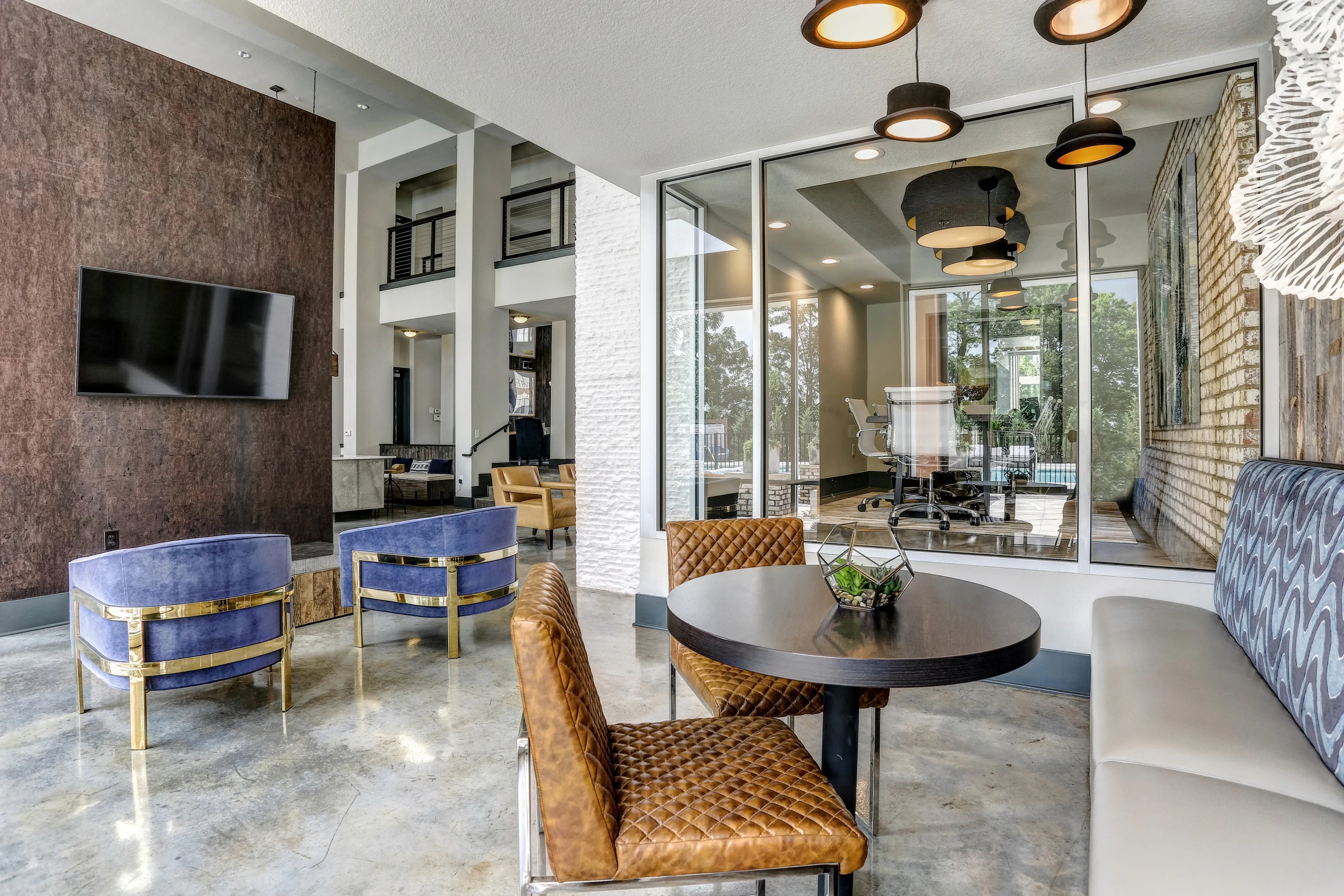 Chic and modern lounge area with plush seating and elegant decor, overlooking a stylish conference room through large glass walls.