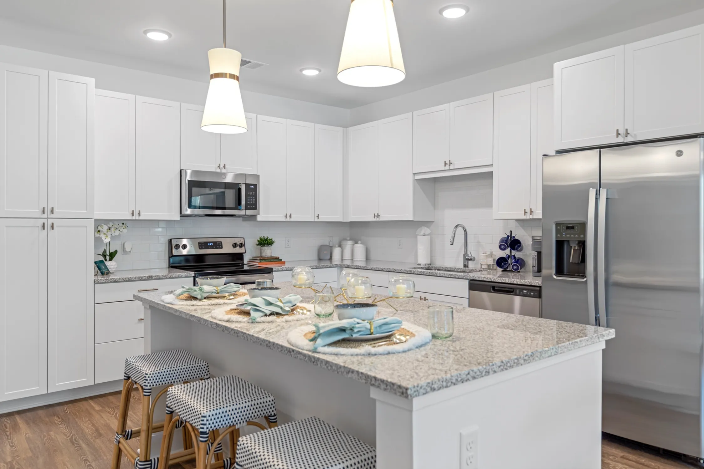 Modern kitchen with a sleek granite island, bar seating, and stainless steel appliances, perfect for entertaining.