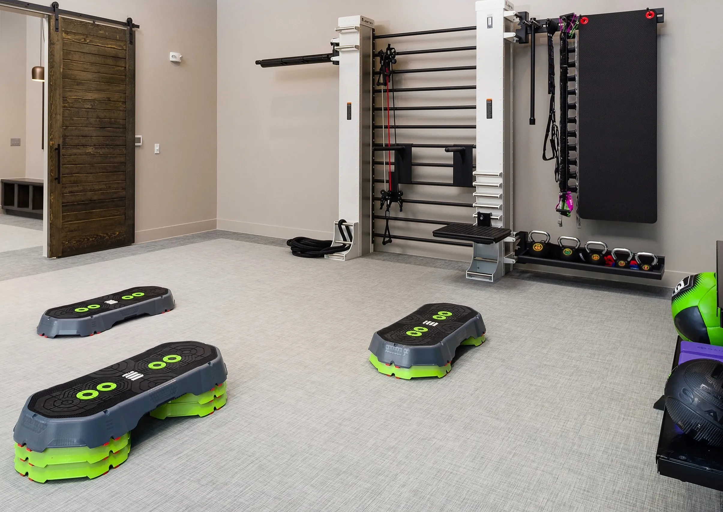 Modern fitness room featuring state-of-the-art gym equipment, sleek design, and spacious workout area.