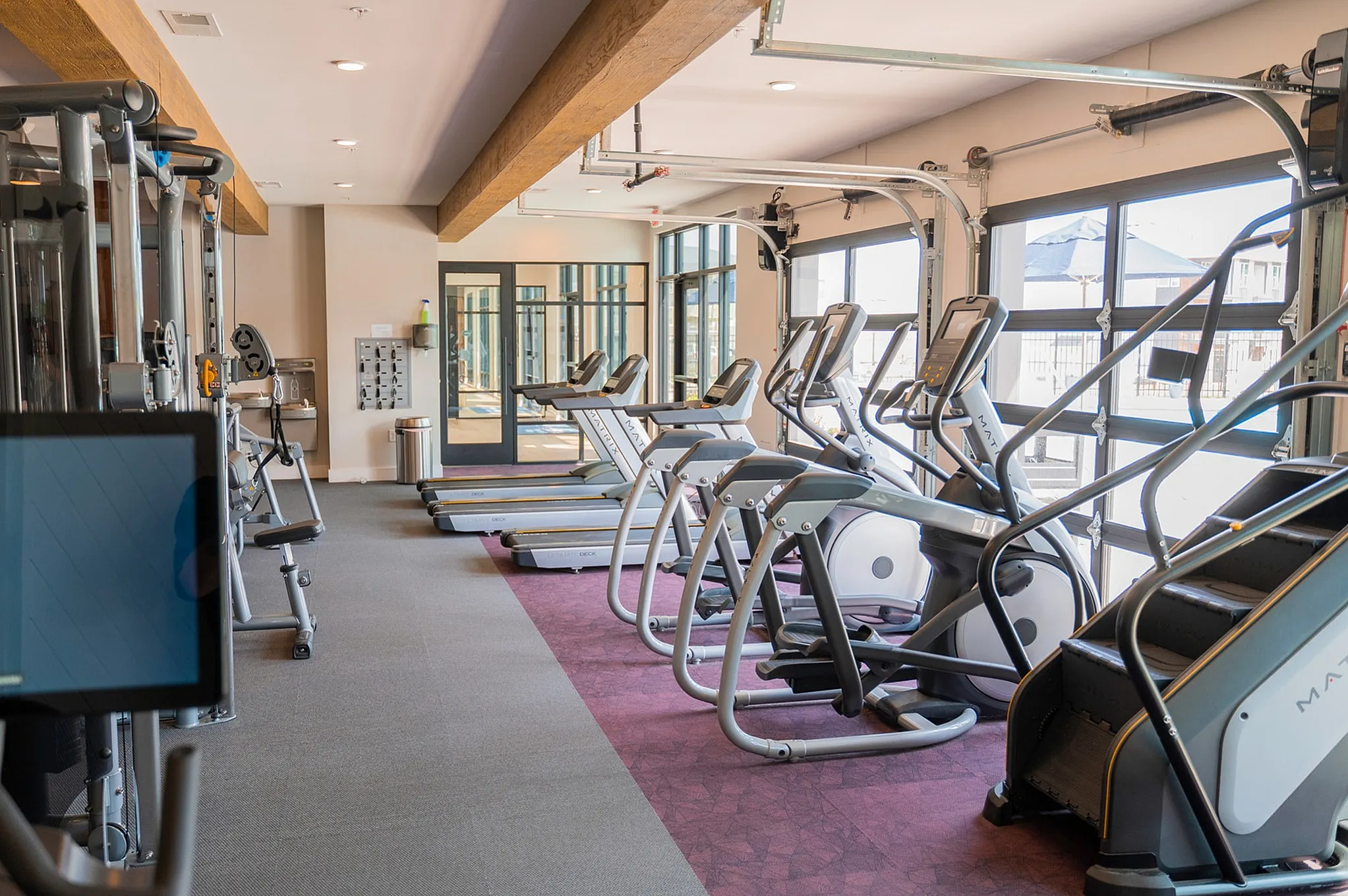 Modern fitness center with state-of-the-art cardio machines, large windows, and sleek design.
