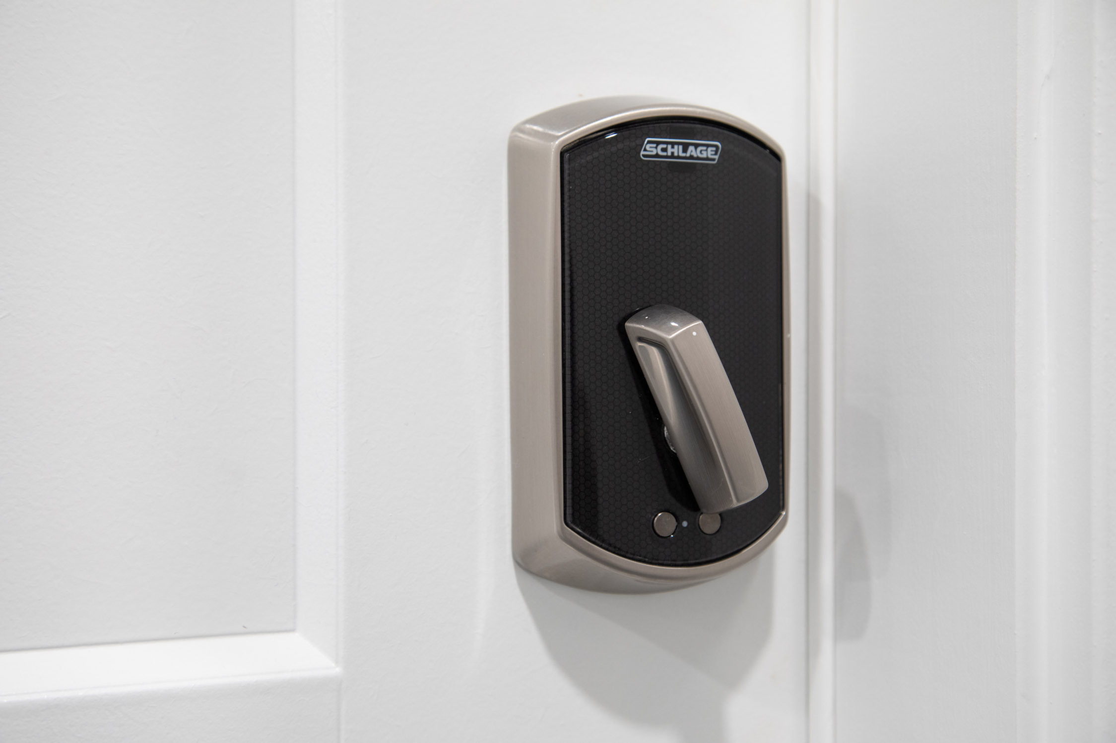 Sleek electronic door lock on a white door, offering modern security and smart home convenience.