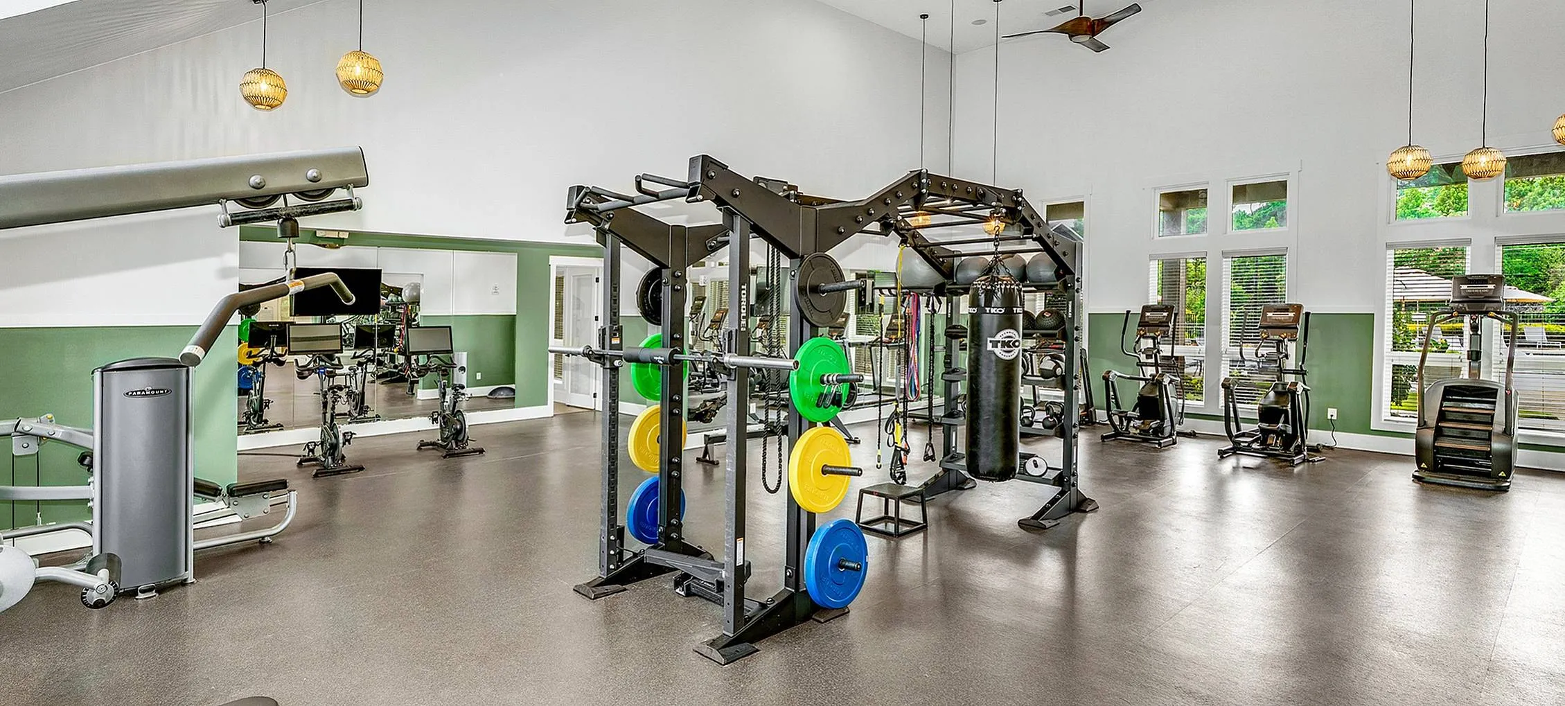 Modern fitness center with state-of-the-art equipment, high ceilings, and abundant natural light.