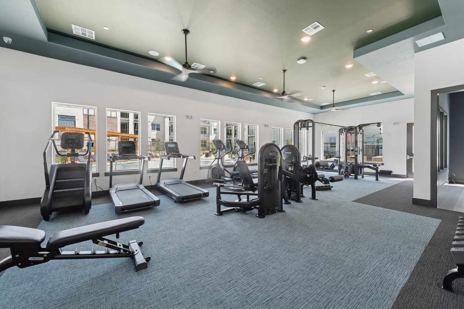 Modern fitness center with state-of-the-art equipment, including treadmills and strength training machines, in a spacious and well-lit room.