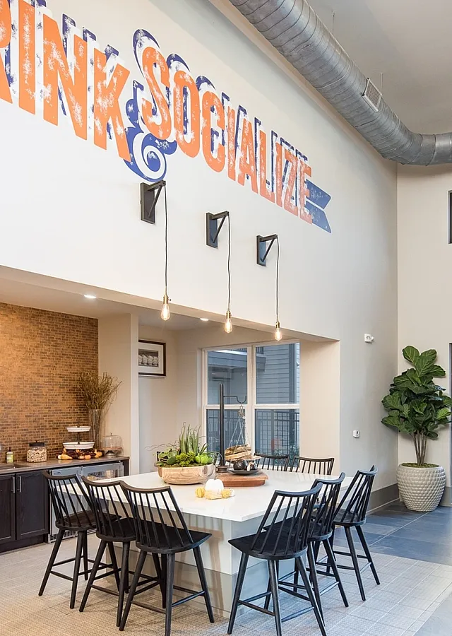 Bright and inviting social lounge with modern seating and bold 'Drink & Socialize' signage.