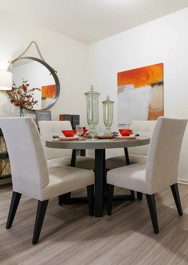 Stylish dining area with a round table, upholstered chairs, and modern decor.