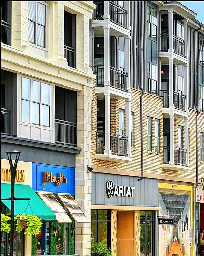 Vibrant urban apartment complex with modern architecture, featuring brick and panel façade above stylish retail shops.