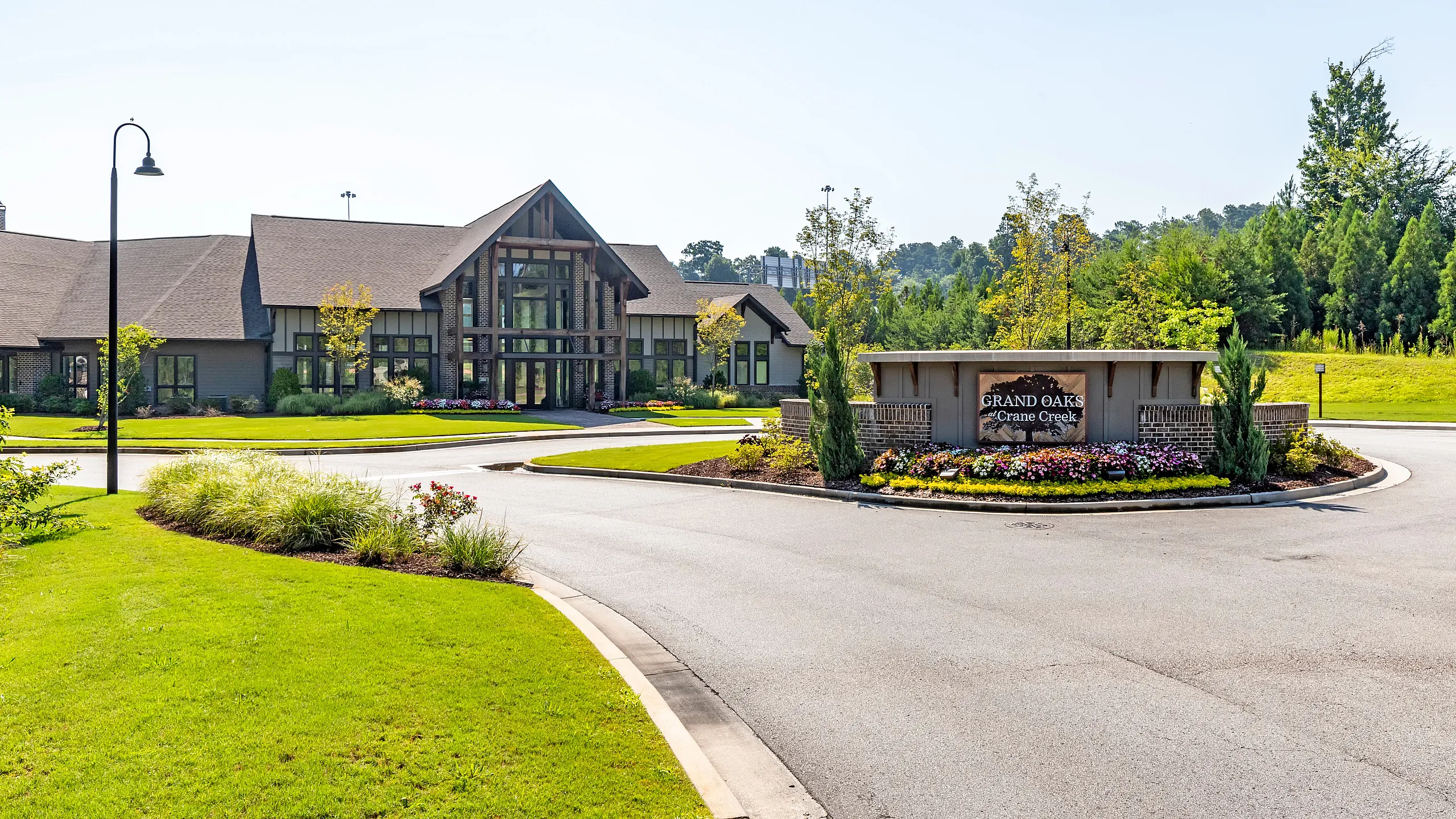 Charming entrance to Grand Oaks community featuring lush landscaping and a modern architectural design.