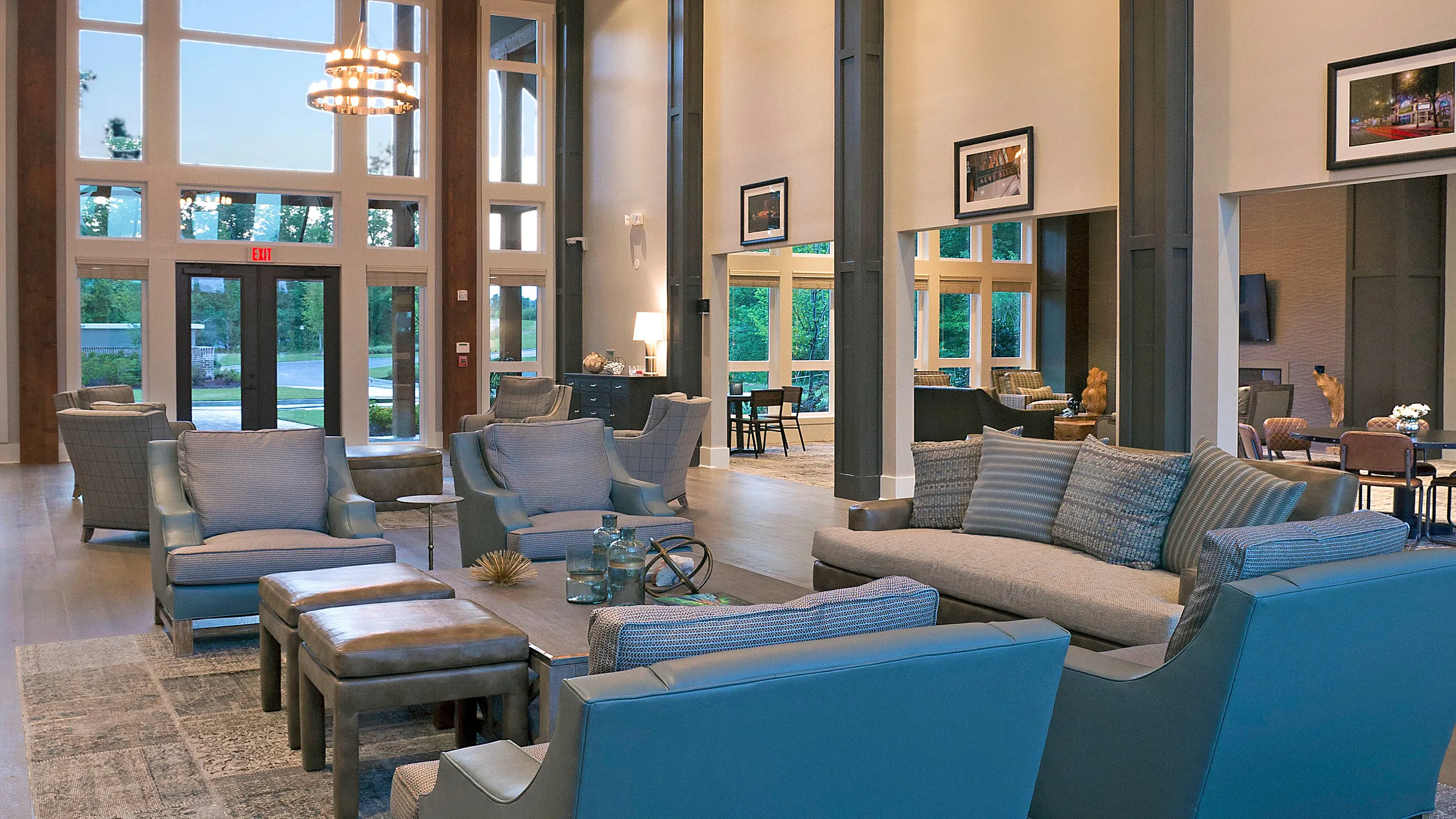 Luxurious apartment lobby with high ceilings, elegant chandeliers, and plush seating, offering a sophisticated and welcoming atmosphere.