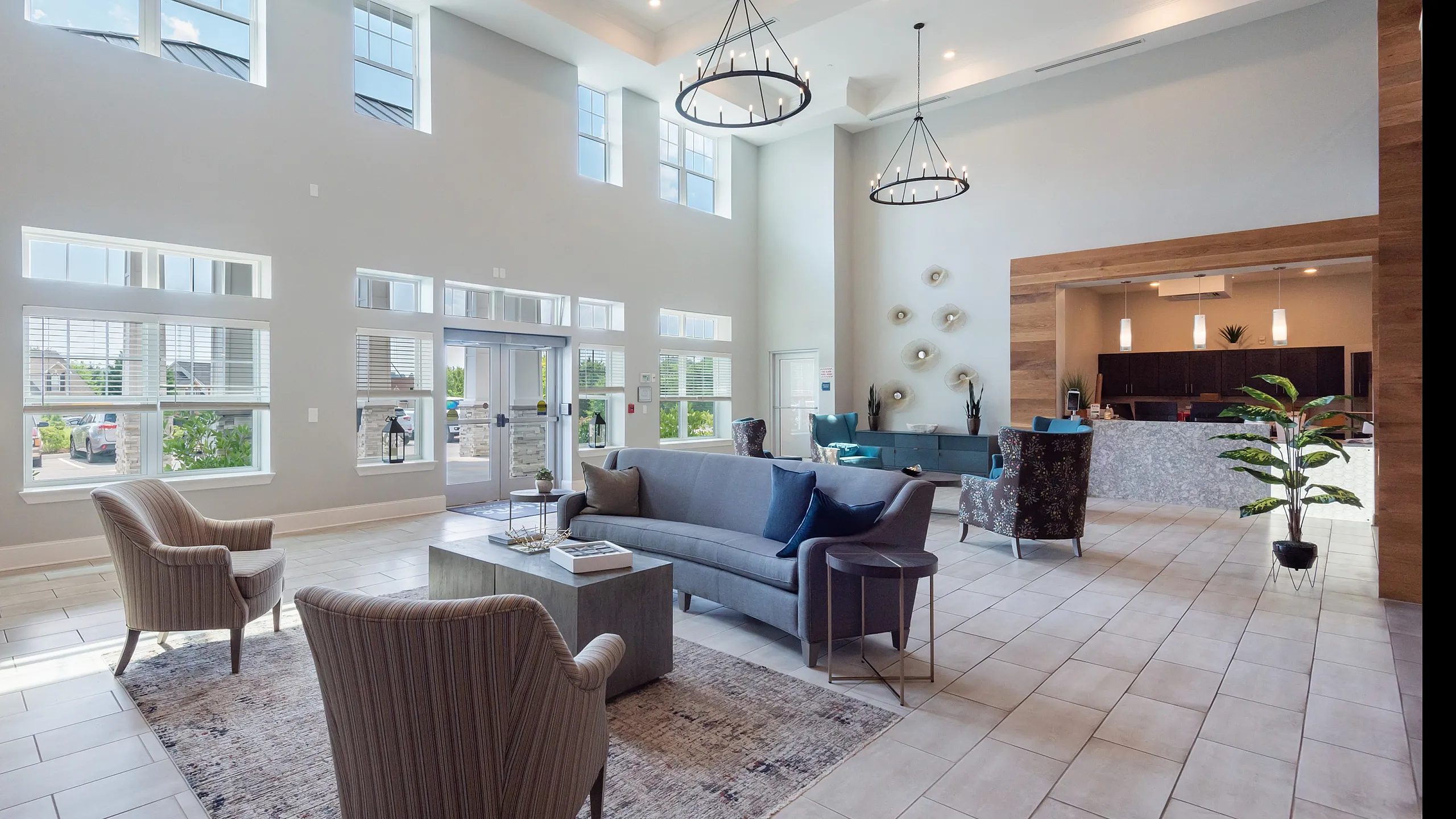 Spacious, modern lobby with high ceilings, elegant seating area, and large windows offering natural light.