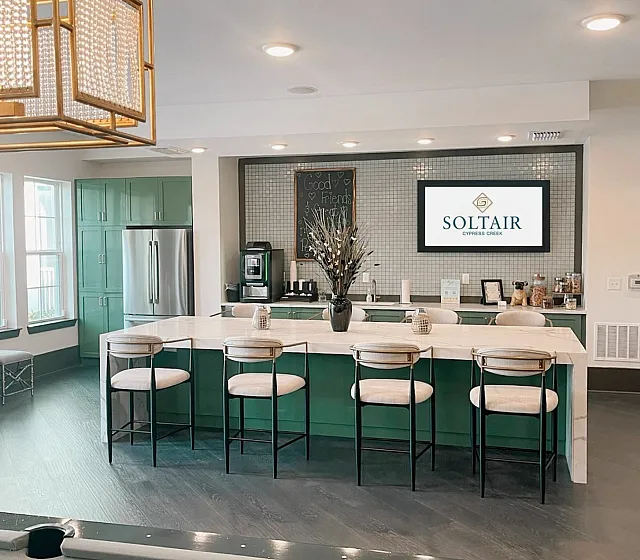 Sophisticated open-concept lounge with a modern kitchenette and stylish seating, complemented by a sleek pool table, ideal for entertaining.