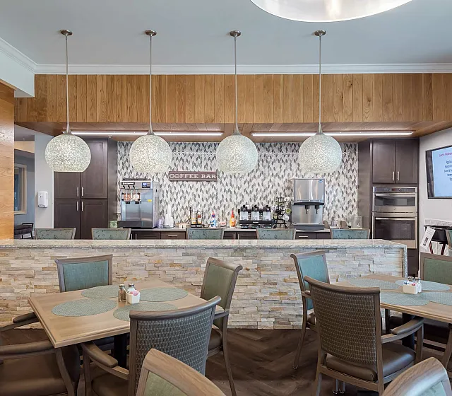 Chic communal area boasting a stylish coffee bar with elegant pendant lighting, modern furniture, and a welcoming atmosphere.