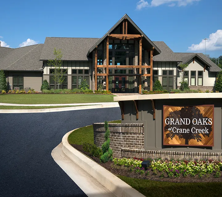 Charming Grand Oaks at Crane Creek showcasing a modern rustic exterior with lush landscaping and welcoming entrance.