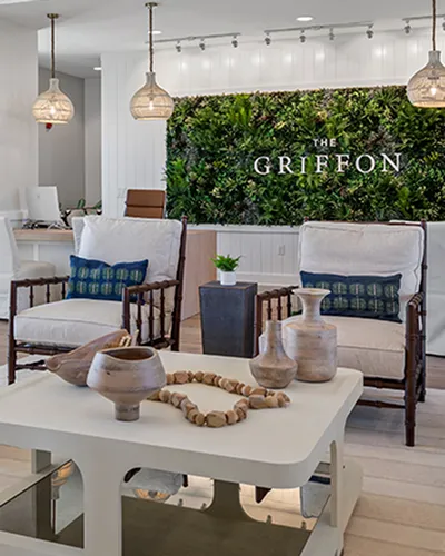 Elegant lobby of The Griffon featuring modern seating, stylish decor, and a lush green wall.