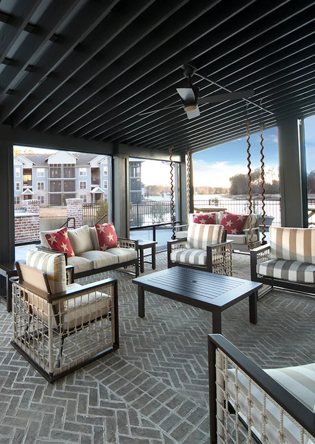 Chic outdoor lounge with stylish furniture set on a cozy patio overlooking serene water views.