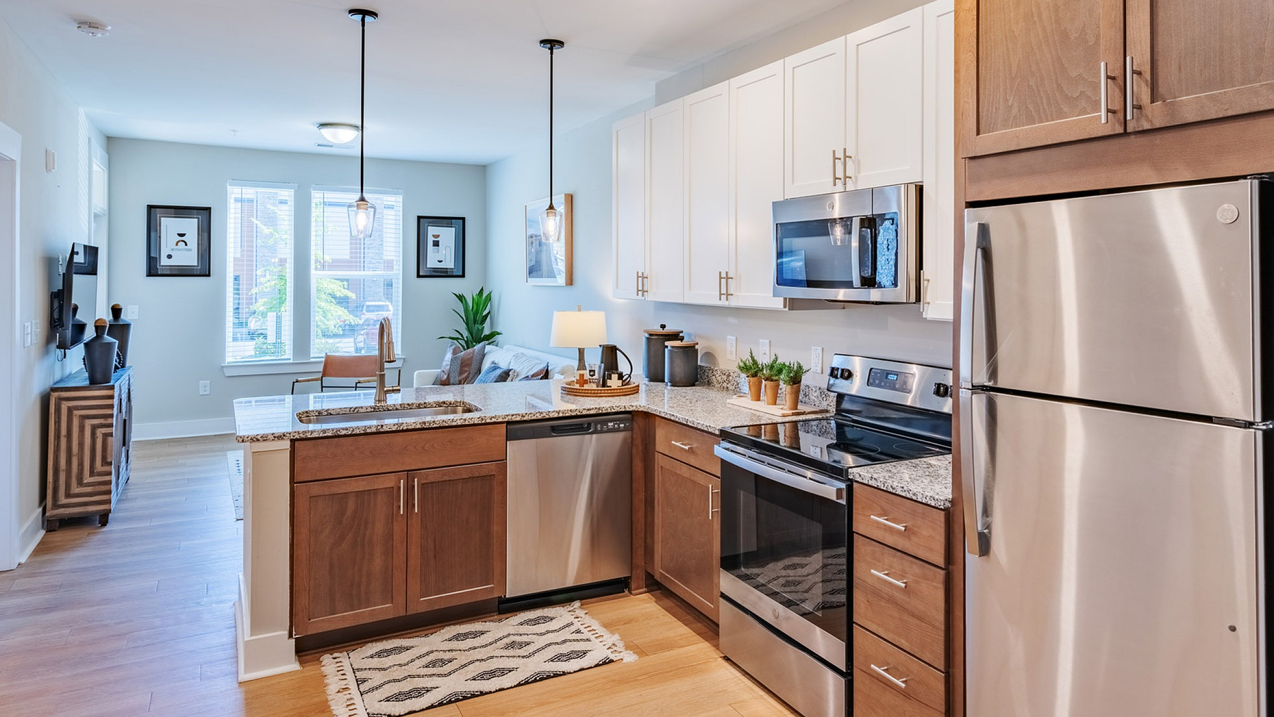 Modern open-concept kitchen with sleek stainless steel appliances, elegant granite countertops, and cozy living area with abundant natural light.