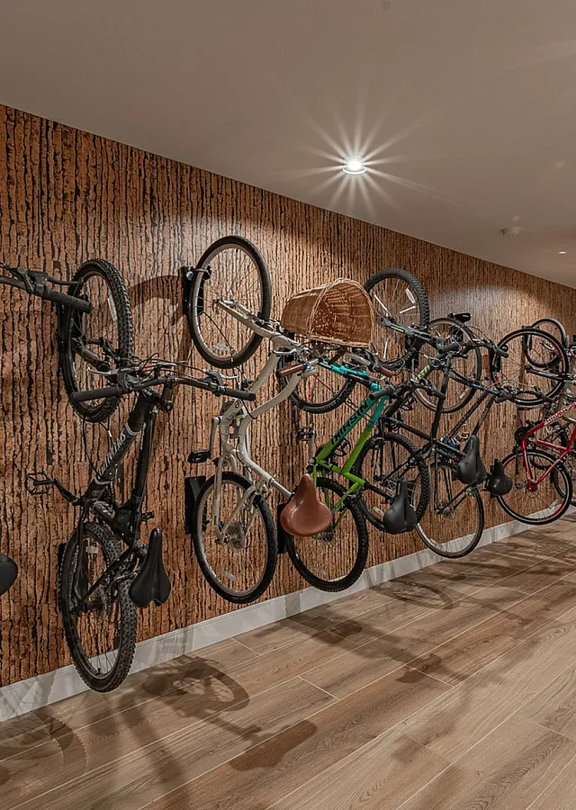 Modern apartment hallway featuring stylish wooden flooring and a dedicated wall-mounted bike storage area.