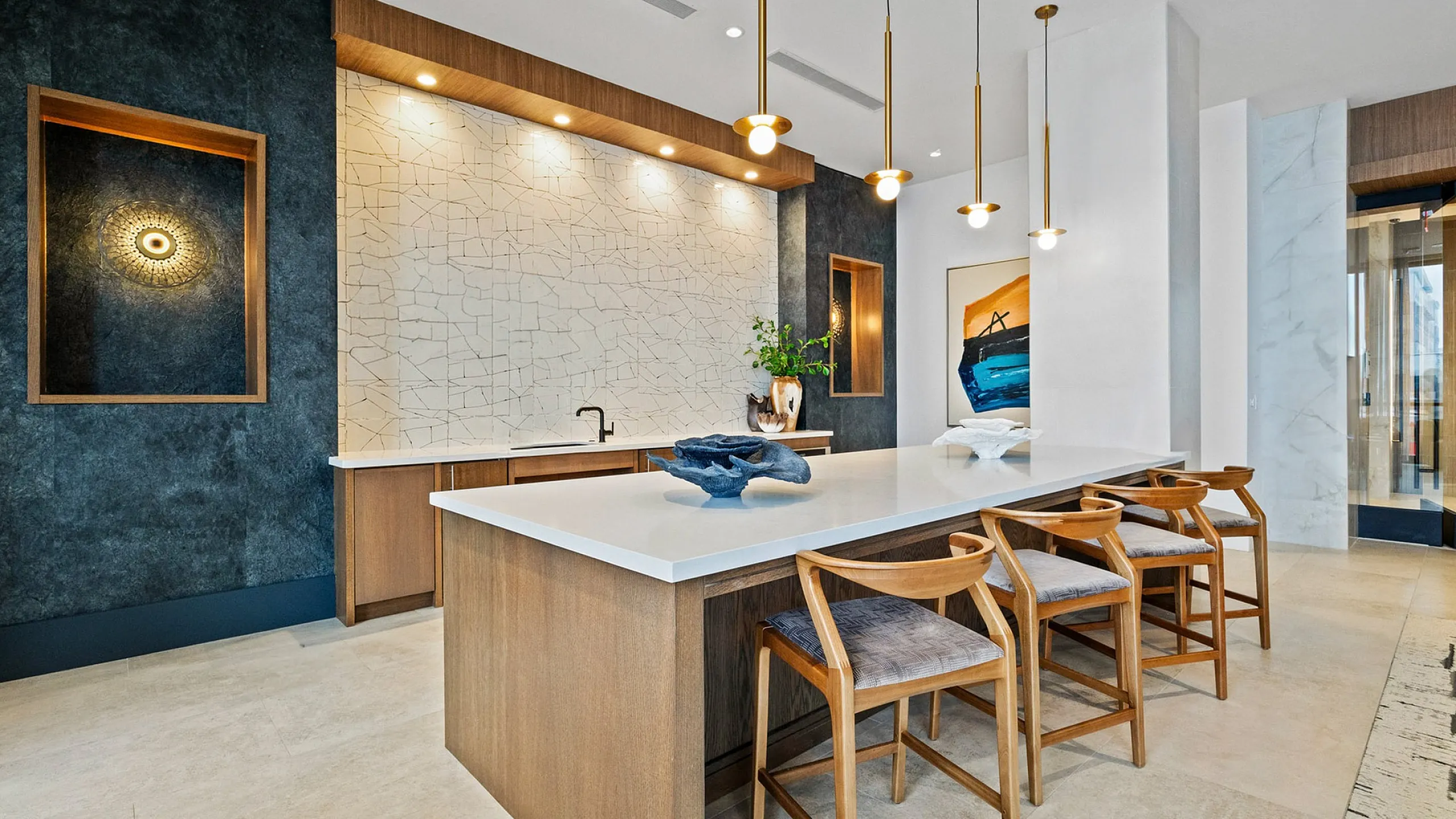 Elegant modern kitchen with sleek white countertops, stylish pendant lighting, and chic wooden bar stools.