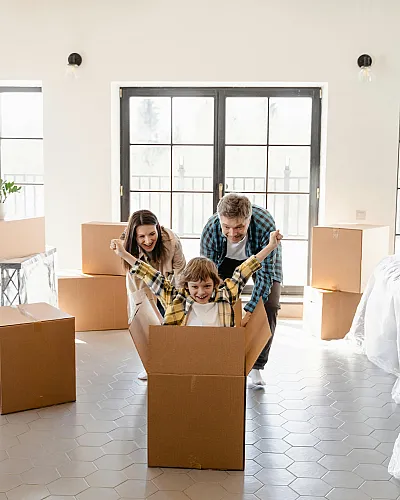 Bright, spacious living area featuring a family enjoying moving day with a playful atmosphere and large windows for natural light.