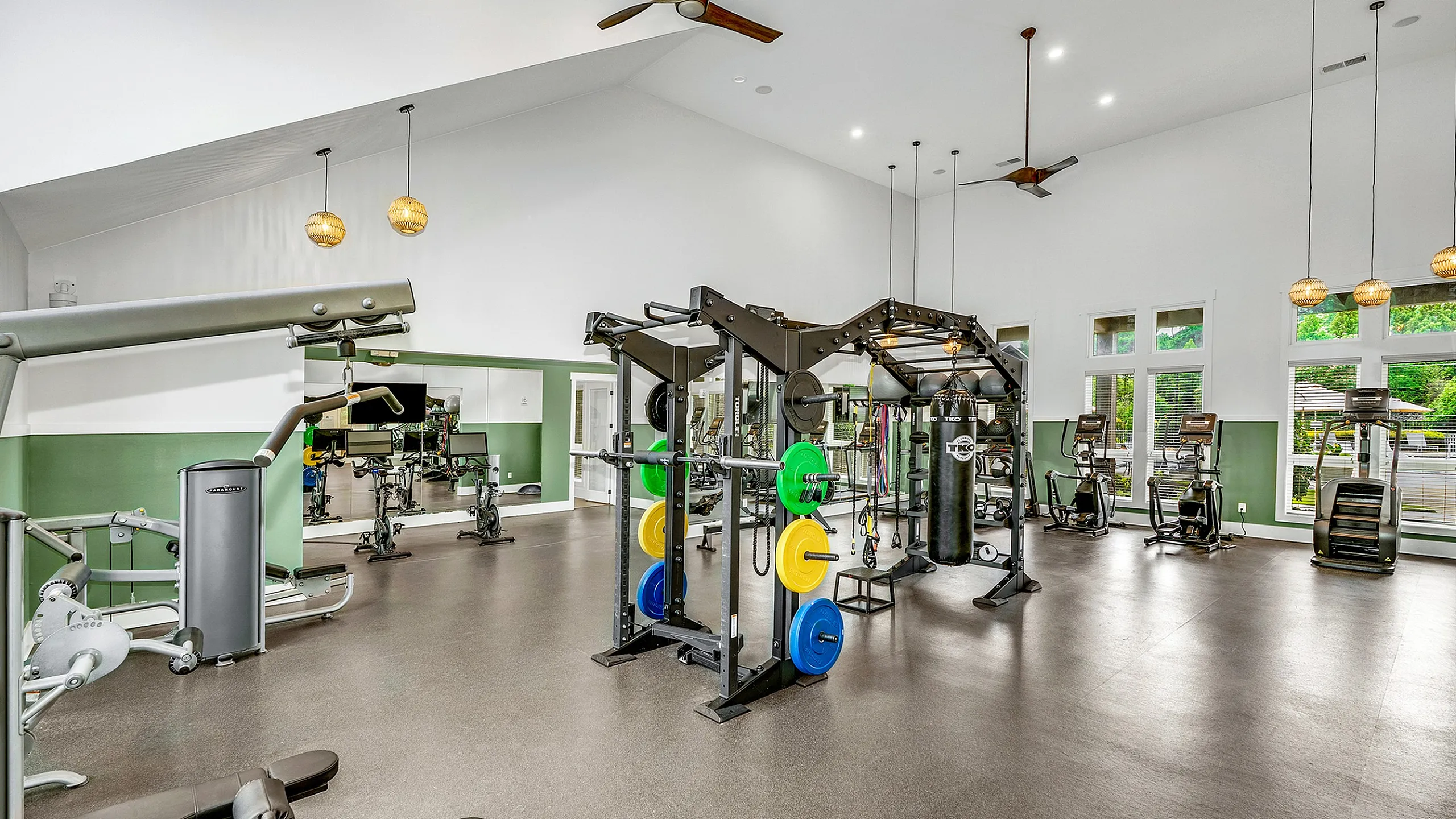 Spacious and modern fitness center with high ceilings, featuring advanced equipment and cardio machines, perfect for an invigorating workout.