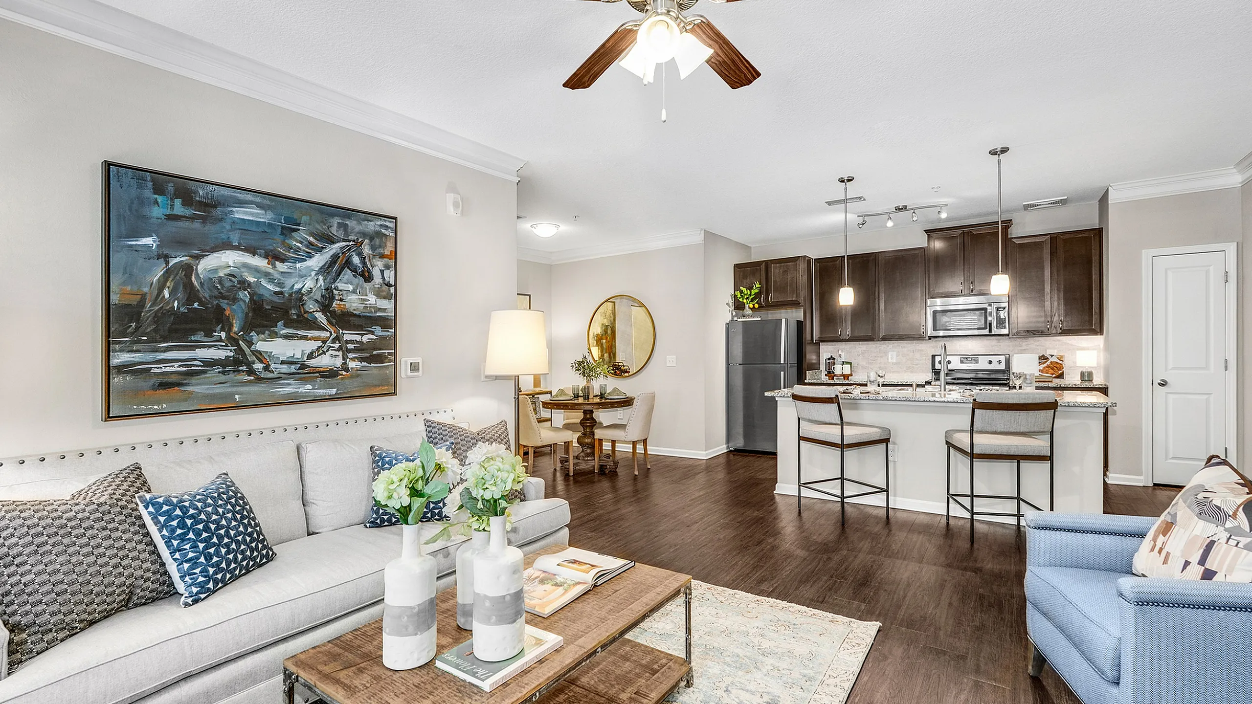 Chic open-concept living space with sleek kitchen, elegant lighting, and cozy seating area.