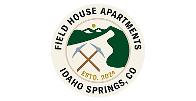 Field House Apartments logo featuring crossed pickaxes, mountain scenery, and 'Estd. 2024' in Idaho Springs, CO.