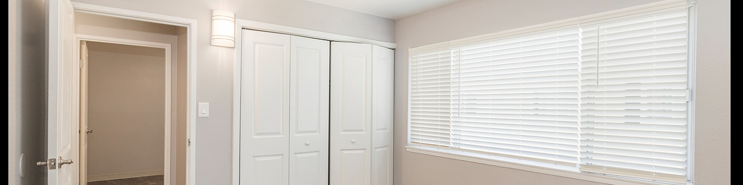 Bright and cozy bedroom with plush carpeting, large window with blinds, and ample closet space.