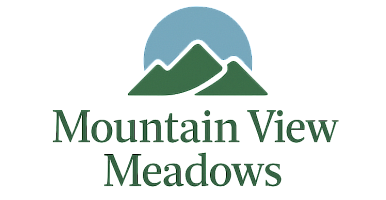 Logo for Mountain View Meadows featuring stylized green mountains under a blue semicircle.