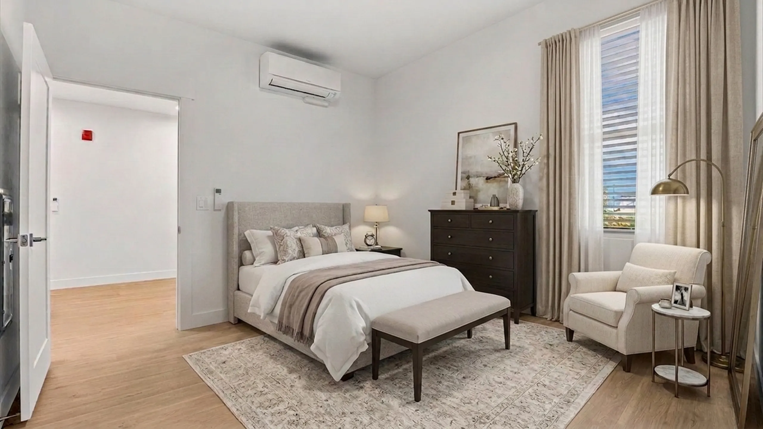 Elegant bedroom with a comfortable bed, cozy armchair, and chic decor, bathed in natural light from a large window.