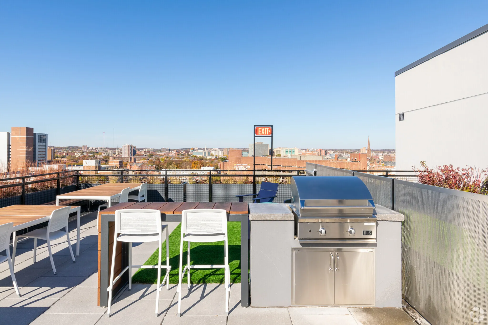 Chic rooftop terrace with modern BBQ grill, sleek seating, and breathtaking city views.