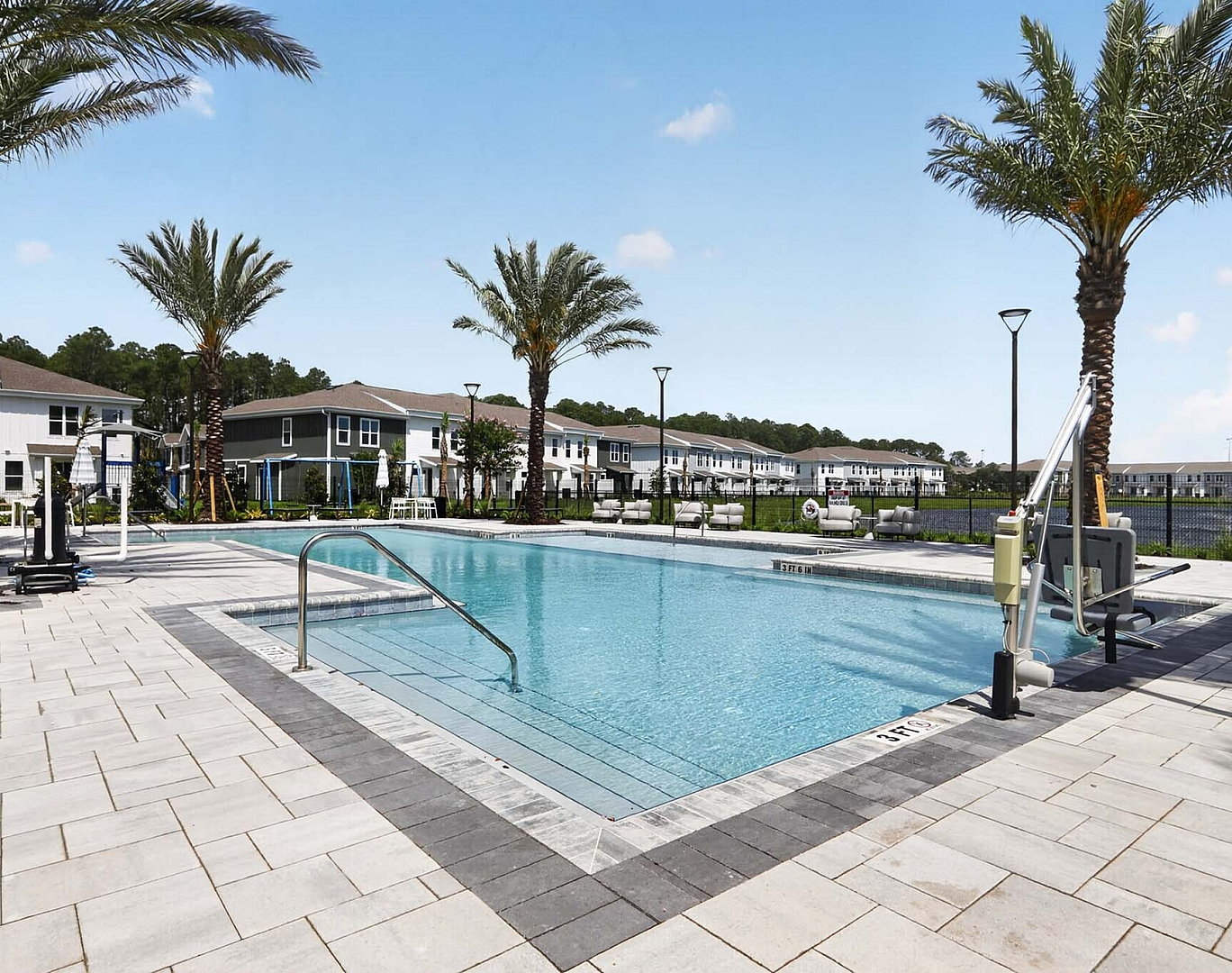 Inviting outdoor swimming pool with palm trees and modern amenities in a scenic residential community.