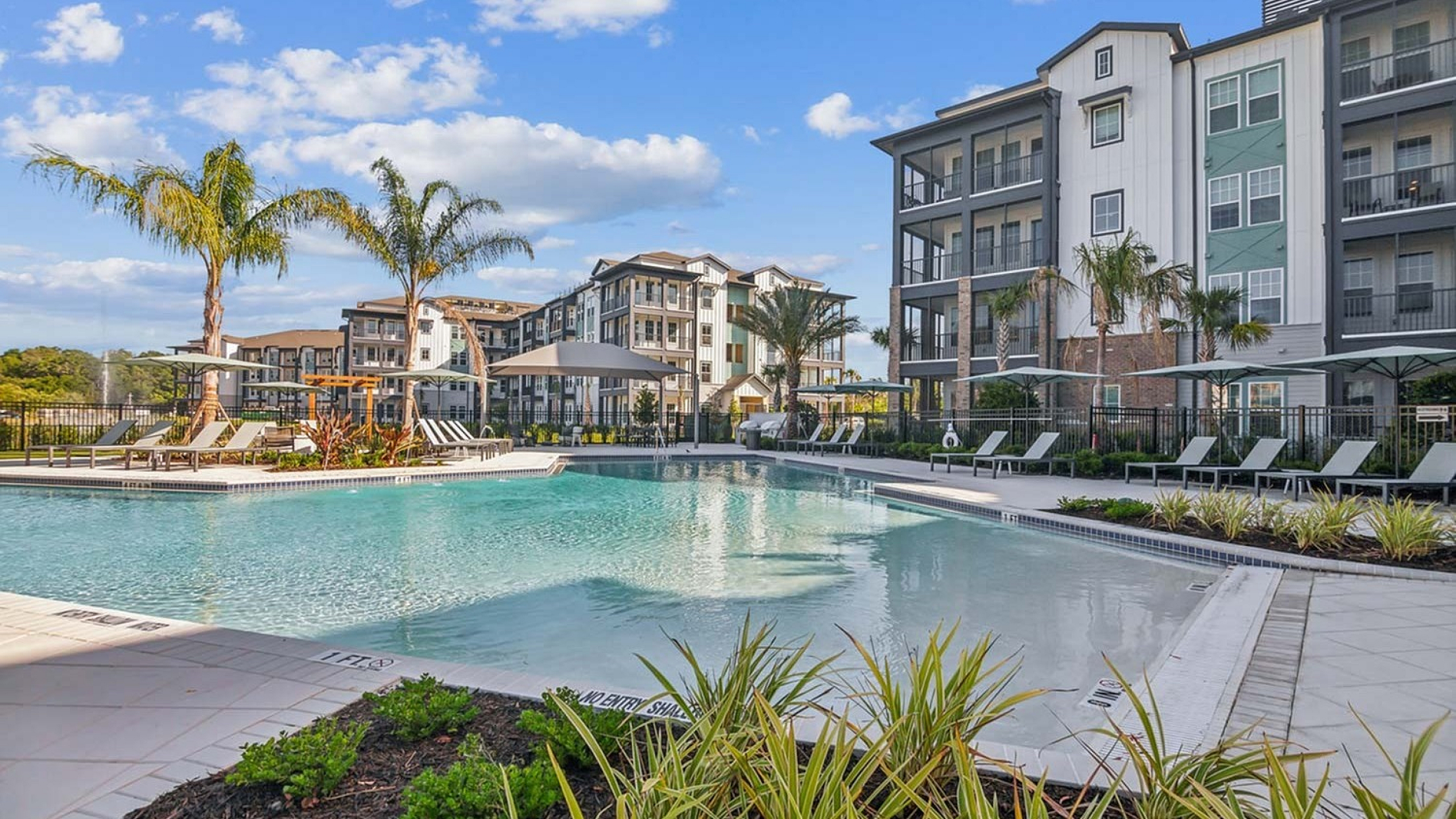 Pool deck and apartment buildings at RISE Sereno