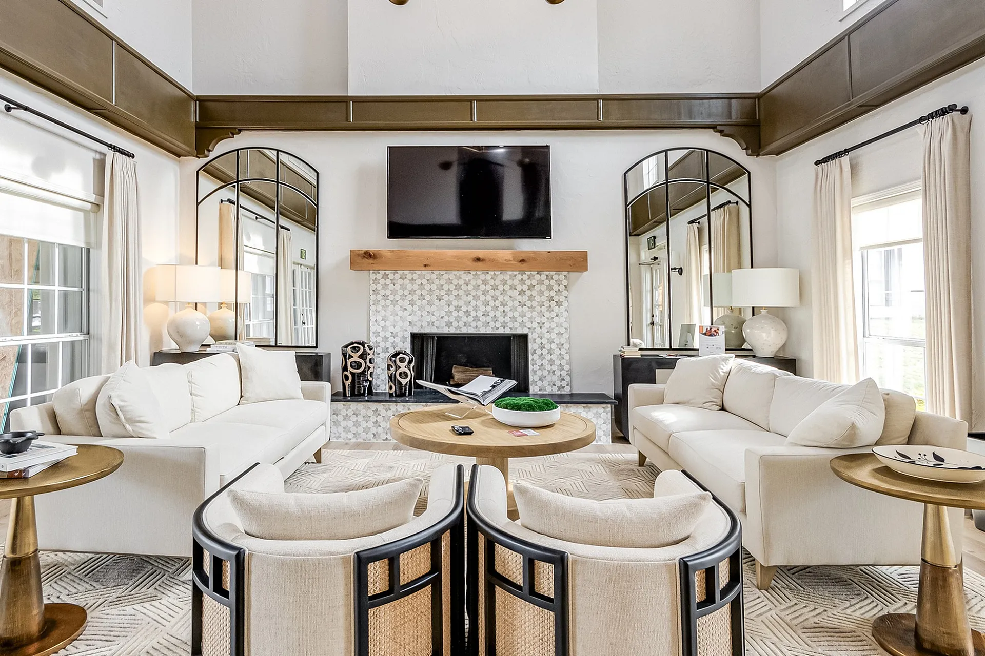 Luxurious high-ceiling living room with elegant decor, chic beige sofas, and contemporary lighting, perfect for sophisticated relaxation.