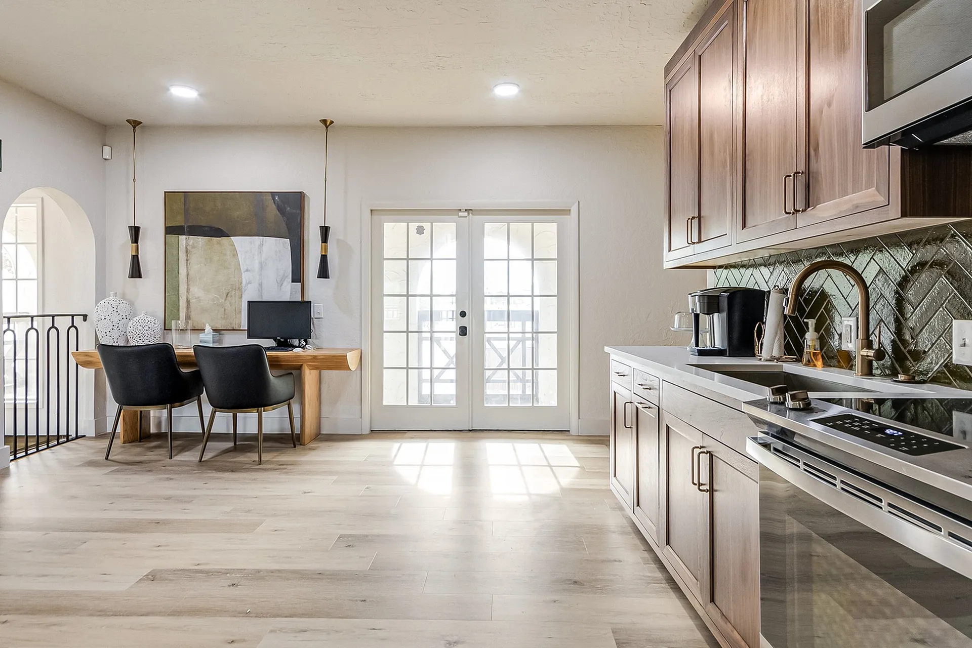 Chic kitchen-dining area with modern wooden cabinets, stylish lighting, and an open layout perfect for entertaining.