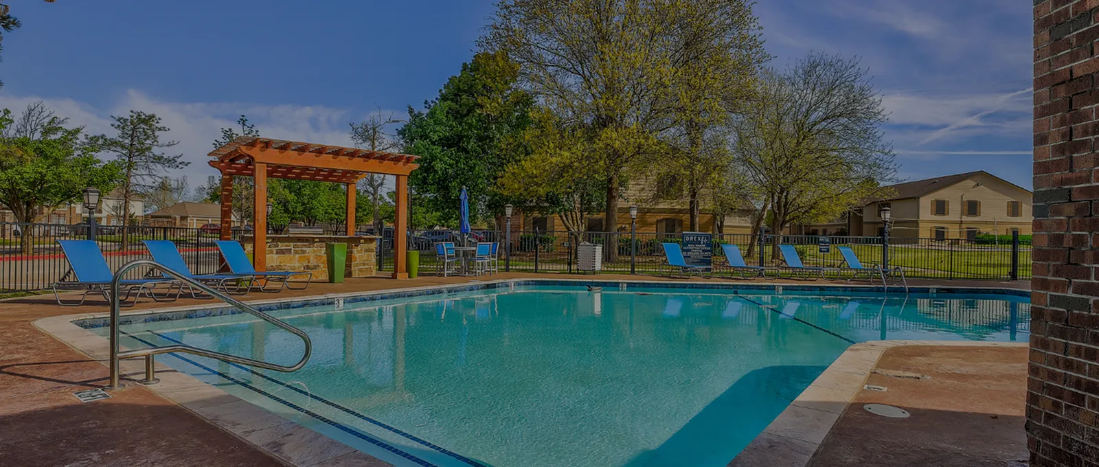 Inviting sparkling pool area with comfortable lounge chairs and a charming pergola, perfect for relaxation and outdoor enjoyment.