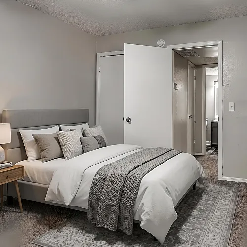 Cozy and elegant bedroom with a plush bed, stylish gray decor, and warm lighting, offering a tranquil retreat.